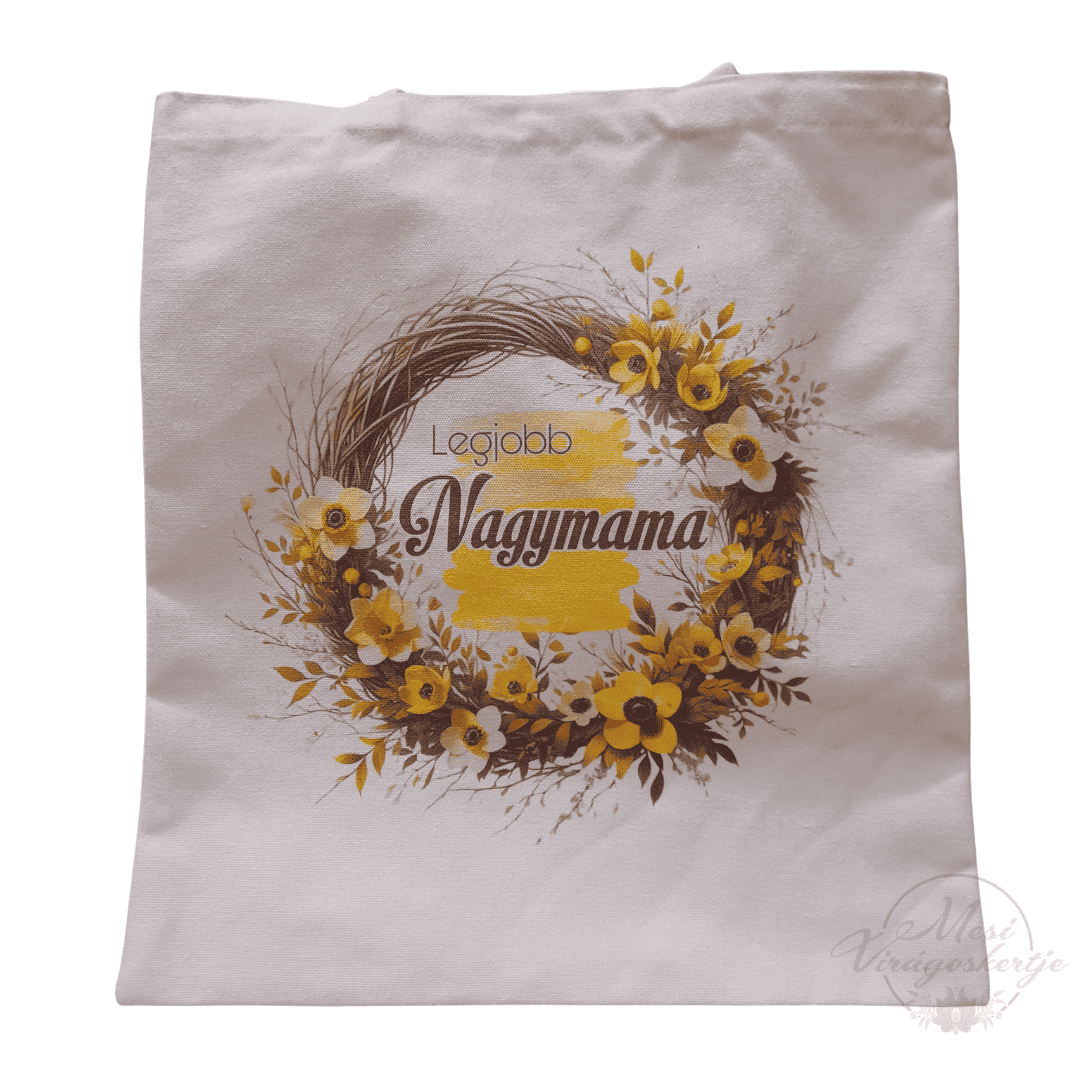 Fehér vászontáska, rajta sárga virágokból és ágakból álló koszorú, közepén „Legjobb Nagymama” felirattal.