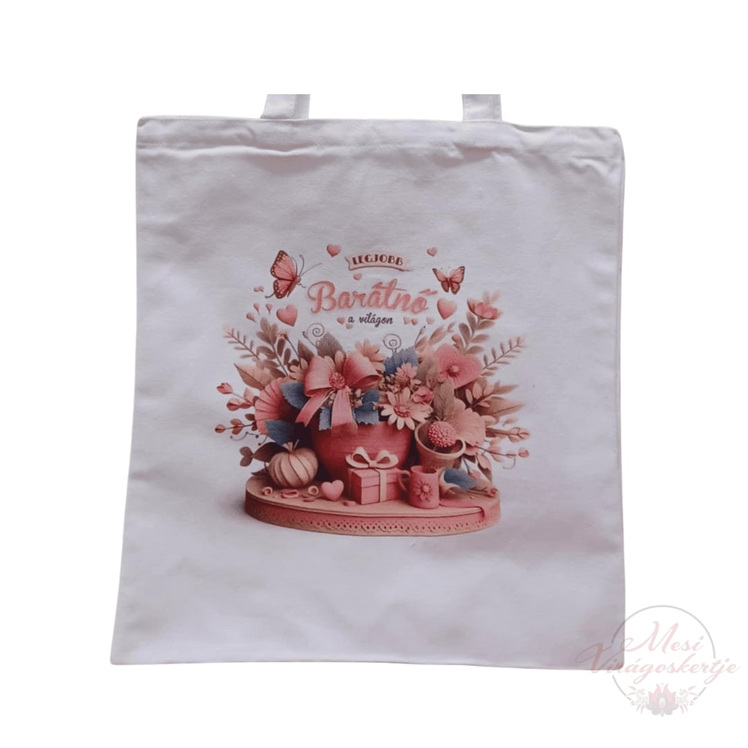 Fehér vászontáska, amelyen egy virágcsokor és ajándékok láthatók. A csokor körül pillangók és szívek vannak. A táska közepén a „Legjobb Barátnő a világon” felirat olvasható. A jobb alsó sarokban „Mesi Virágoskertje” logója látható.