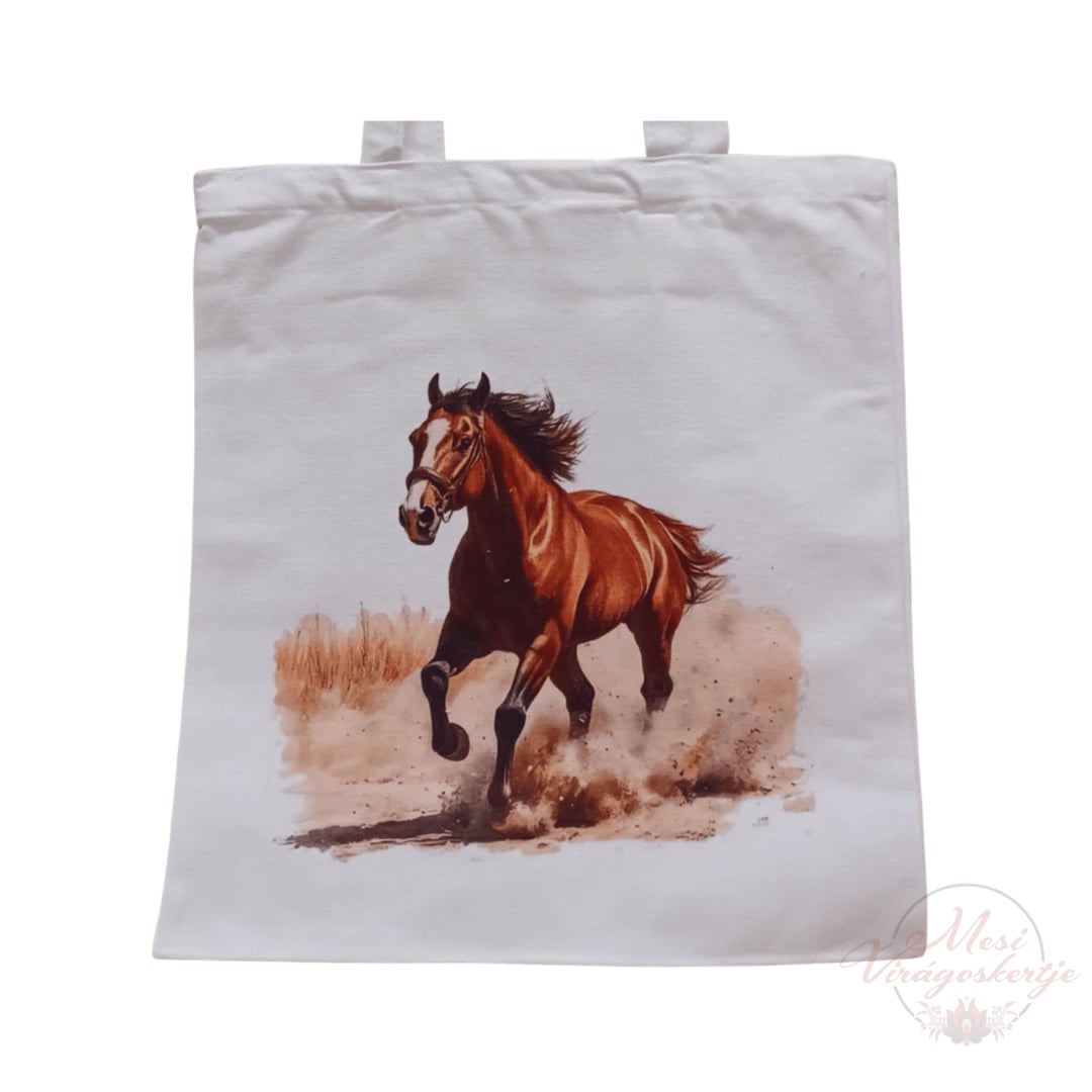 Fehér vászontáska, amelyen egy vágtató barna ló látható porfelhővel körülvéve. A jobb alsó sarokban „Mesi Virágoskertje” vízjel szerepel.